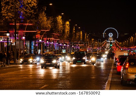 PARIS - NOV 30: Avenue des Champs-Elysees with Christmas illumination and ferris wheel at horizon on November 30, 2013 in Paris, France. Champs-Elysees is one of the most famous streets in the world.
