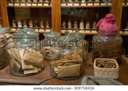 Pharmacy Traditional Chinese Medicine. Glass bottles with natural medicines on the table Chinese pharmacies. Natural medicine made from dried herbs in pharmacy shop. Therapeutic drugs from herbs.