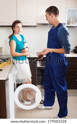 Woman And Worker With Washing Machine At Home Interior Woman And Worker With Washing Machine At Home Interior