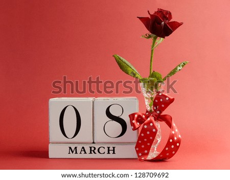 Red theme, save the date white block calendar for International Women's Day, March 8, decorated with flower, vase and polka dot ribbon.