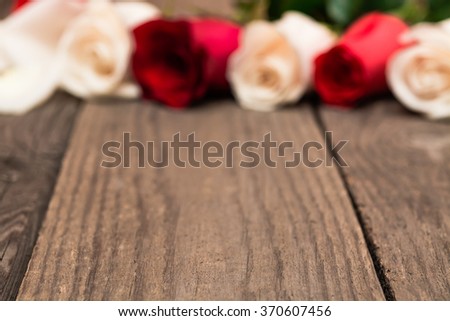 Red and white roses on a light wooden background. Women' s day, Valentines Day, Mothers day. Copy space, selective focus. Natural optical blur.
