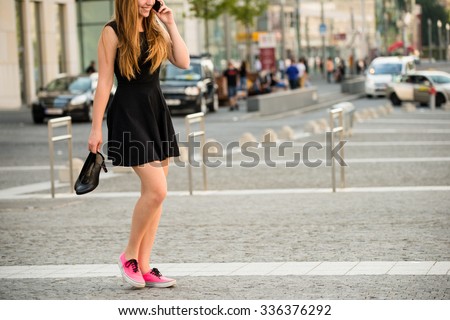 https://thumb9.shutterstock.com/display_pic_with_logo/134167/336376292/stock-photo-young-woman-walking-down-street-in-sneakers-and-high-heels-shoes-holding-in-hands-336376292.jpg