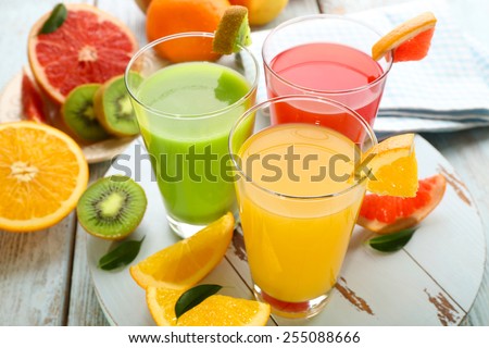 Fresh juices with fruits on wooden table