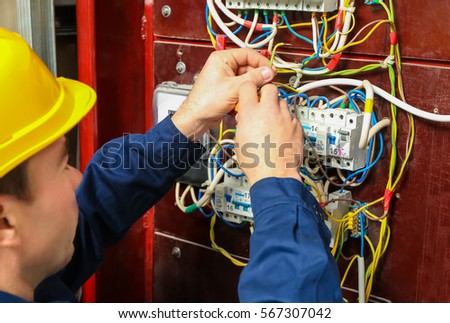 Electrician connecting wires in distribution board