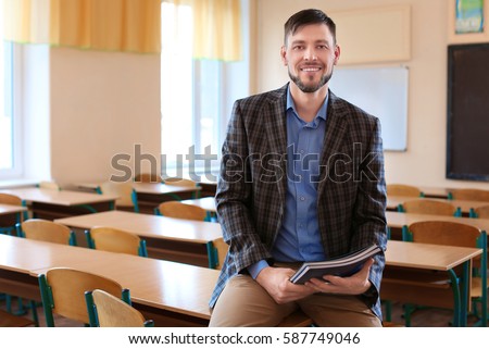 Portrait of happy teacher in classroom