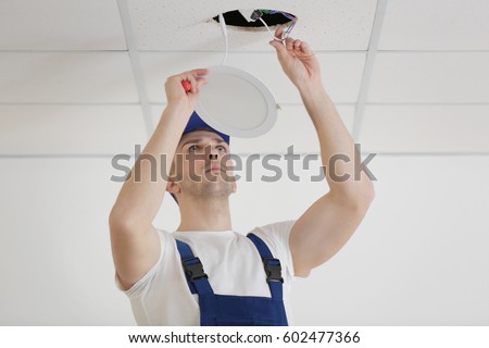 Electrician repairing ceiling light
