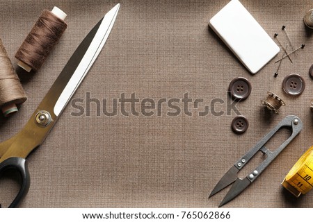 Set of tailoring tools and accessories on fabric, top view