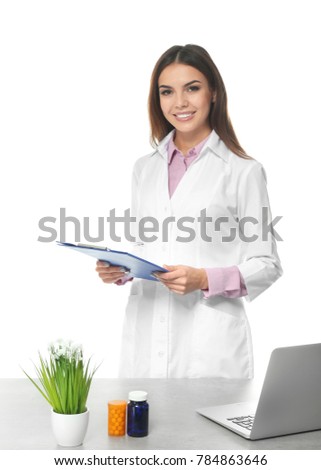 Young female pharmacist with clipboard on white background