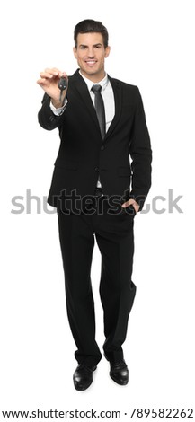 Salesman in formal suit holding car key on white background