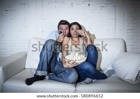 https://thumb9.shutterstock.com/display_pic_with_logo/1390159/580896652/stock-photo-young-happy-attractive-couple-having-fun-at-home-enjoying-watching-television-horror-movie-show-or-580896652.jpg