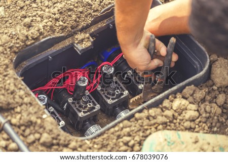 Drip irrigation valve box with valves for water plants with automatic watering system. Selective focus and vintage style.