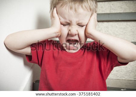 Neglected lonely child leaning at the wall