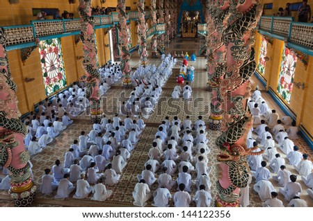 HO CHI MINH, VIETNAM - DEC 24: People praying in Cao Dai Temple on Dec 24, 2012, in Ho Chi Minh, Vietnam. Caodai is a Vietnamese religion mixing different religions from around the world.