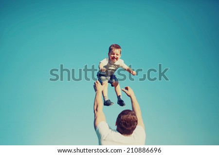Vintage colors photo happy father and child having fun outdoors, carefree, blue sky, family, travel, vacation, childhood, father's day - concept