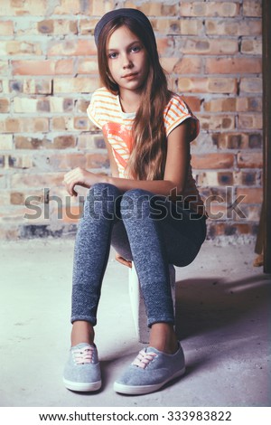 Fashion Pre Teen Girl Dressed In Sports Wear And Sneakers Posing Over Brick Wall Fashion Pre Teen Girl Dressed In Sports Wear And Sneakers Posing Over Brick Wall