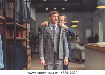 Mature tailor and customer in atelier