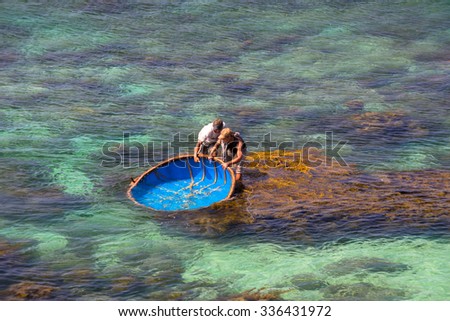 LY SON ISLAND-QUANG NGAI-VIETNAM. APRIL 26,2014. A view of fisher men on round boat in LY SON ISLAND - QUANG NGAI-VIETNAM
