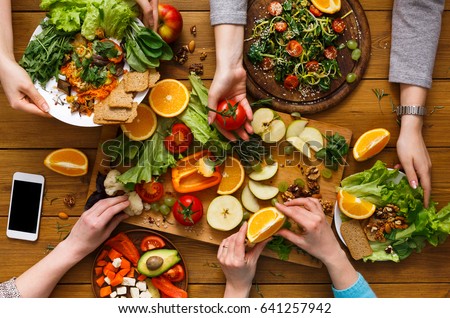 Mesa de jantar vegetariana saudável.  Mulheres juntas em casa, comendo frutas e legumes, vista superior, postura plana, colheita