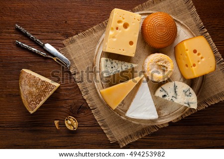 Mix cheese on wooden board with grapes. Top view.
