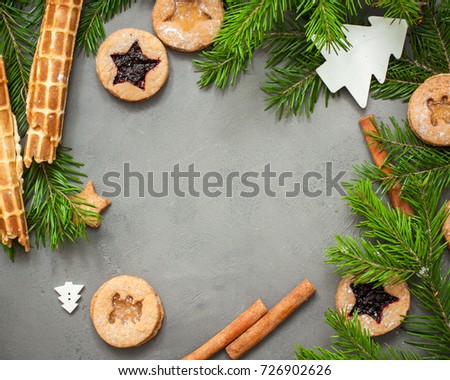 Ginger homemade cookies with strawberry jam on gray concrete background with Christmas tree. View with copy space. Flat lay, top view. Christmas Border -banner.