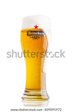 LONDON,UK - MARCH 23, 2017 : A Glass of Heineken Lager Beer on white background with foam. Heineken Lager Beer is a pale lager beer produced by the Dutch brewing company Heineken International