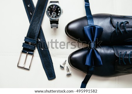 Men's accessories men's shoes, watches, glasses, bow tie, sleeve shirt and strap. Black and white minimalistic composition on a white background. Classic men's accessories. Top view