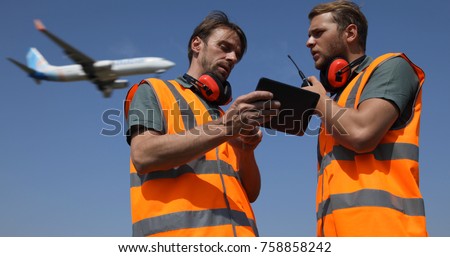 Airport Team Activity, Men Work on Digital Tablet, Talk on Walkie Talkie Collaborating with Air Traffic Control Tower, Airplane Flying Over Aircrew Controllers Ground Crew, Aircraft Passing Overhead