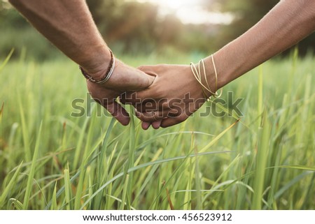 https://thumb9.shutterstock.com/display_pic_with_logo/163108/456523912/stock-photo-close-up-shot-of-man-and-woman-holding-hands-in-grass-field-young-couple-in-love-with-hand-in-hand-456523912.jpg