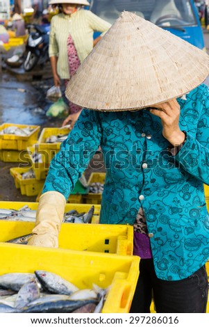 A Vietnamese woman is listening her phone in Long Hai Fish market, Ba Ria - Vung Tau, Vietnam