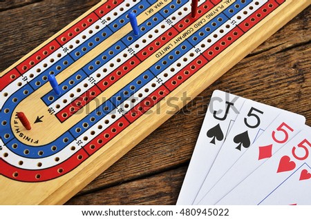 A Top View Image Of Wooden Cribbage Board With Playing Cards On Table A Top View Image Of Wooden Cribbage Board With Playing Cards On Table