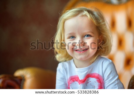 beautiful little girl, laughs and poses on the camera, joyful emotions