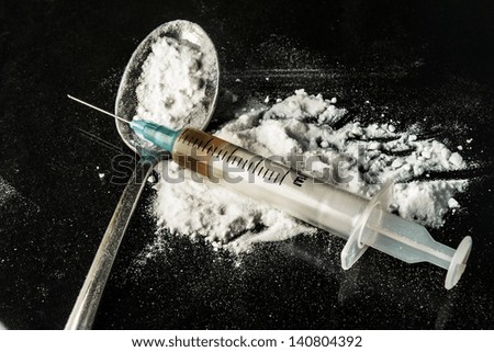Drug syringe and cooked heroin on spoon