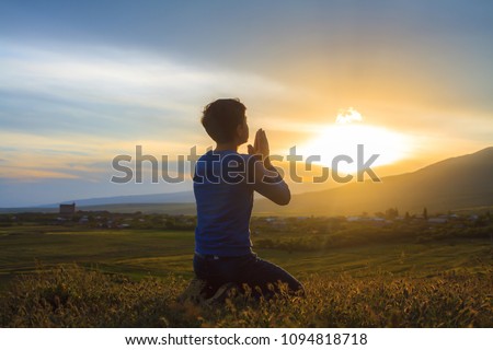 A boy kneeling and praying