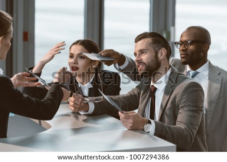 group of businesspeople having argument with airport receptionist
