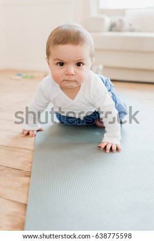 Funny Baby Boy Crawling On Yoga Mat With Angry Expression Funny Baby Boy Crawling On Yoga Mat With Angry Expression