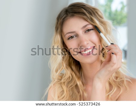 https://thumb9.shutterstock.com/display_pic_with_logo/1682770/525373426/stock-photo-young-blonde-woman-applying-make-up-cosmetic-product-beautiful-smiling-girl-with-wavy-hair-use-525373426.jpg