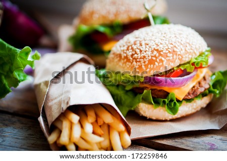 Closeup of home made burgers on wooden background - stock photo