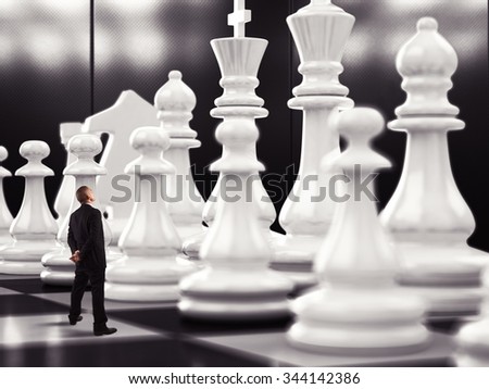 Businessman looks up to big chess pawn