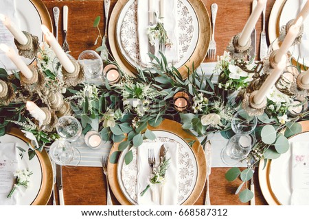Aerial View Of Winter Green Garland On A Wedding Receptions Head Table With Gold Place Setting Aerial View Of Winter Green Garland On A Wedding Receptions Head Table With Gold Place Setting