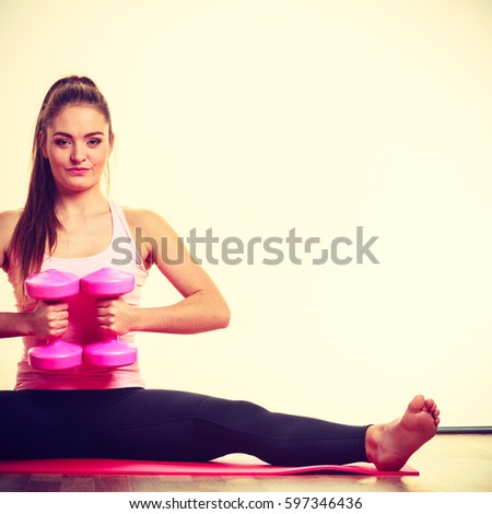 Woman exercising with dumbbells. Fit fitness sporty girl gaining building muscles. Bodybuilding.