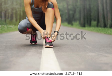 young sporty woman preparing to run in early foggy morning in the beautiful nature forest, wellness concept