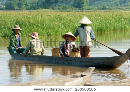 DAK LAK- VIET NAM- JUNE11: Group of Asian farmer go to work by row boat on Lak lake in summertime, family of ethnic minority, grass on lake, amazing view for Asia travel, Daklak, Vietnam, June11, 2015