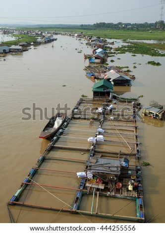 DONG NAI, VIET NAM- JUNE 5: Group of floating house on La Nga fishing village, river with green grass and hyacinth, residence of people who live with fish farming at Dongnai, Vietnam