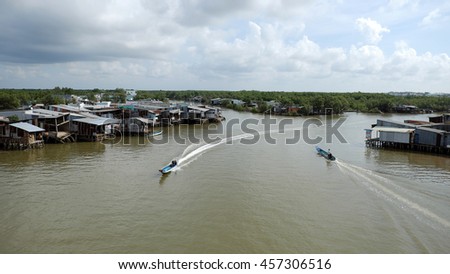 CA MAU, VIET NAM- JULY 16, 2016: Waterway at Mekong Delta, motor boat move on Nam Can river, poor residential with house make from metal sheet among mangrove forest, Camau, Vietnam