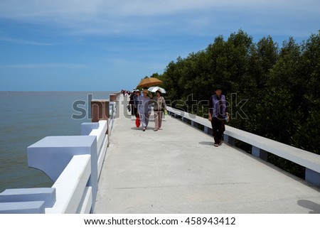 CA MAU, VIET NAM- JULY 16, 2016: Group of tourist travelling Dat Mui, a geography place people walking on breakwater along the beach