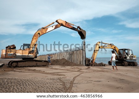 CA MAU, VIET NAM- JULY 16,2016: Vietnamese excavator driver control vehicle to build breakwater at beach to protect seaside from erosion at Camau, Vietnam