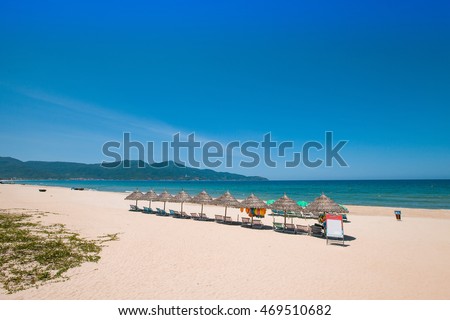 Beach umbrellas and deck chairs in front of the My Khe beach in Da Nang, Vietnam