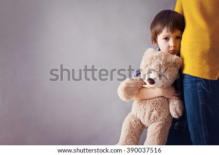 Sad little child, boy, hugging his mother at home, isolated image, copy space. Family concept