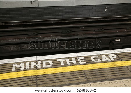 LONDON, ENGLAND - 20 APRIL 2017: A sign painted on a platform on the London Underground warns commuters to MIND THE GAP. The phrase was first introduced in 1969 on the London Underground. Editorial
