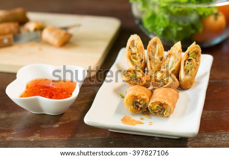 Veg. Spring Rolls, on white dish and wooden table / Selective focus